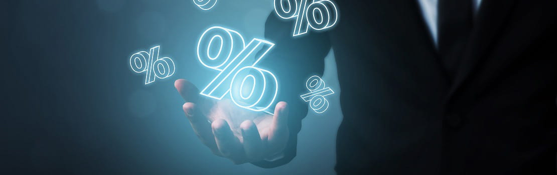 A holographic percentage sign is held in the hand of a suited figure.